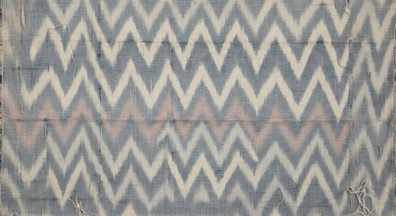 Close-up of a gray, beige, and pink chevron patterned fabric with a subtle texture.