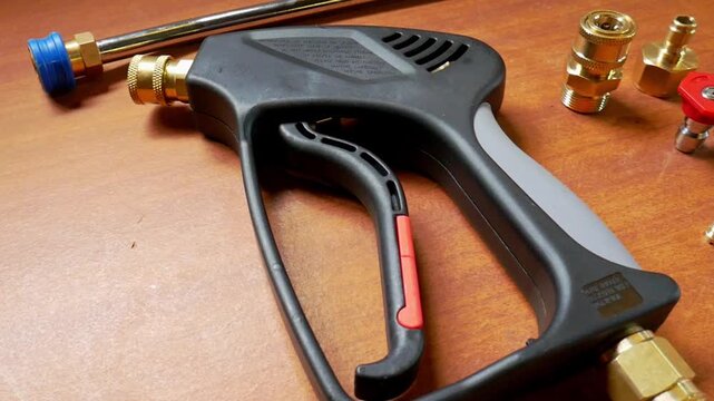 Top to bottom panning shot of pressure washer trigger gun with quick release accessories