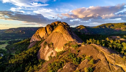 Aerial view of a rocky mountain range at sunset with lush greenery