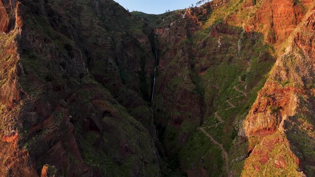 Zig zag mountain pass and waterfall down cliff at seaside Paul do Mar, aerial