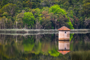 Obraz premium An old stone water tower in the middle of a dam - horizontal