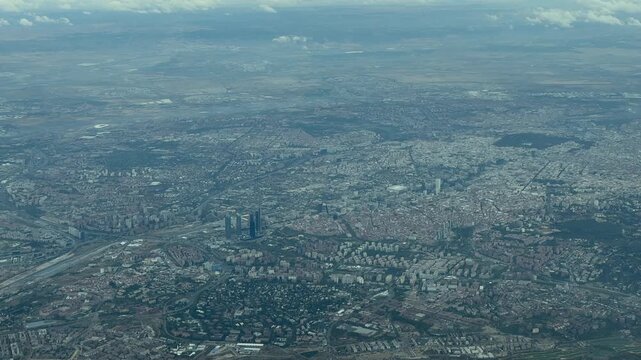 An alevated left side aerial view of Madrid city early in the morning, taken from a plane cokpit. handheld camera shot.