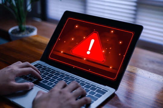 Computer screen showing a red warning sign with an exclamation mark, symbolizing system error, malware attack, or cybersecurity threat. Concept of data protection, computer virus,