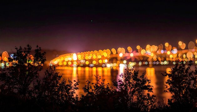 Bokeh lights blur a distant bridge at night