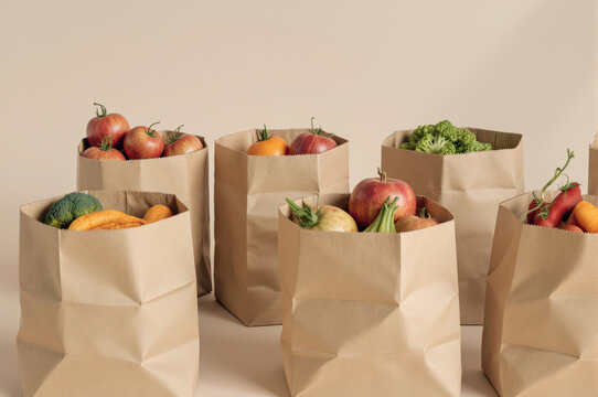 Close up view of several brown paper grocery bags filled with fresh organic fruit and vegetable. hopeful concept for food donation, charity food drive, and healthy eating
