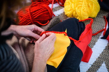 Hands making bunting in Indigenous colours, black, red, yellow - horizontal