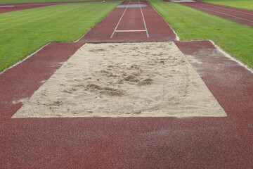 An empty long jump pit on the track.