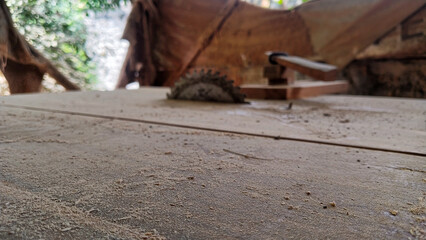 Rusty circular saw blade on dusty woodworking table in workshop
