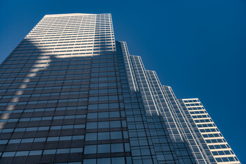 Obraz premium Business city. City architecture. Modern glass building. Reflective glass architecture. Architecture business district. Building architecture. Business building. Glass building. Urban business core