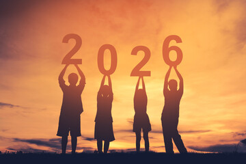 Family stands together holding up the numbers 2026 to welcome the new year.