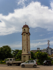 Obraz premium Vertical view of the historic Khan Clock Tower landmark with street traffic under a cloudy sky in Colombo, Sri Lanka.