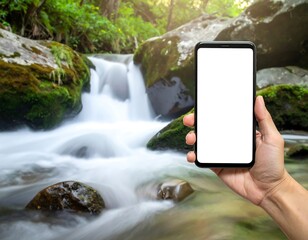 A hand holding a smartphone with a white screen in front of a blurred stream flowing down mossy rocks