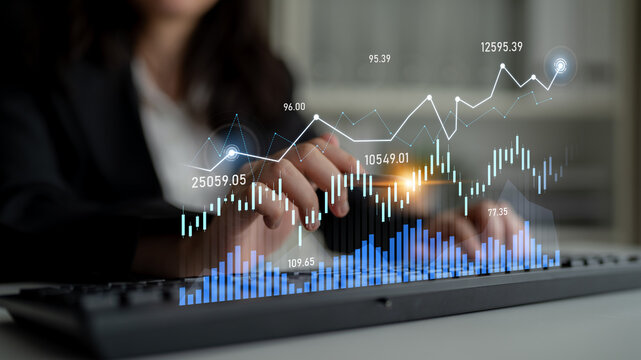 A business professional scrutinizes financial data on a keyboard, with digital graphs illuminating stock market trends and analysis in a modern office environment. Scalp