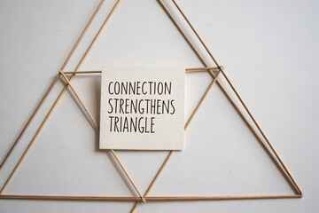 A square note with the message connection strengthens triangle on a string design