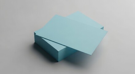 Stack of light blue cards neatly arranged on a gray surface, with two cards slightly offset on top.