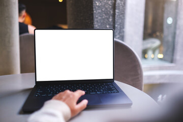 Mockup image of a woman working on laptop computer with blank white desktop screen in cafe