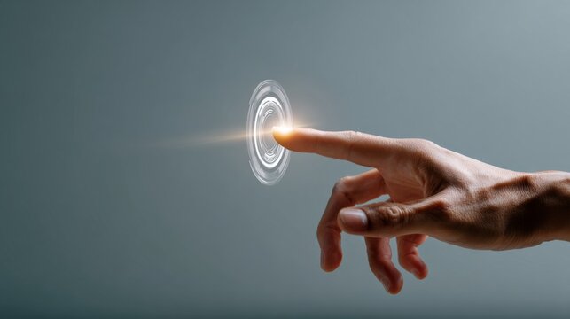 Human hand touching a futuristic glowing interface button isolated on a solid gray background