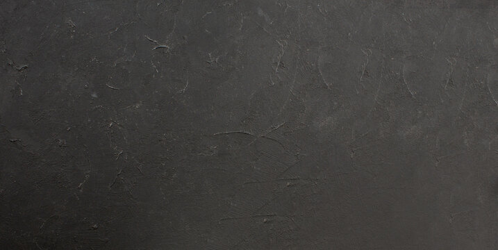 Close up textured dark gray background with subtle speckled imperfections creating a moody and abstract visual