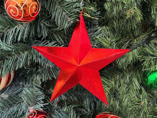 christmas tree decoration, close up of shiny red star on tree