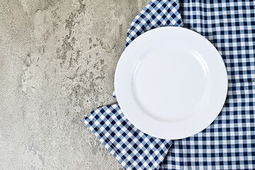 Top view of empty white plate with napkin. Grey or gray cement on the background. copy space, empty, free, negative, text, design. flat lay. high angle, above.