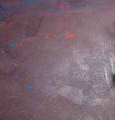 Abstract textured background with subtle hints of red and blue evoking a sense of weathered or aged...