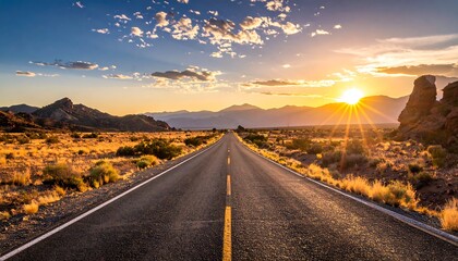 A straight asphalt road leads towards the vibrant setting sun. The landscape showcases mountains, arid land, and a picturesque, cloudy sky