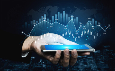 A close-up of a hand holding a smartphone that displays colorful graphs and financial data, set against a dark background with a global map, representing modern technology in business analytics. Scalp