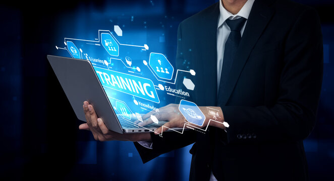 A businessman in a suit is holding a laptop displaying a vibrant digital training concept and education icons, showcasing the intersection of technology and professional development. Tessel - Powered by Adobe