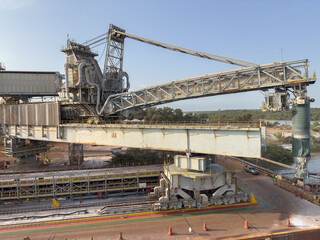 Modern port terminal unloading ore, bauxite, and petroleum coke with massive screw unloader  aluminum production. heavy machinery, cargo terminal, industrial equipment, seaport, maritime logistics 33