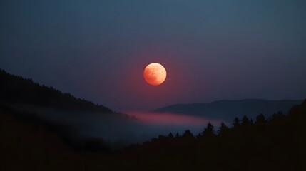 Obraz premium A dramatic blood moon rises over a misty mountainous landscape at twilight