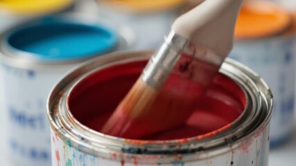 A paint can with a brush ready for a fresh coat of color on a surface. Paint can with brush – close-up for renovation, painting, and DIY projects