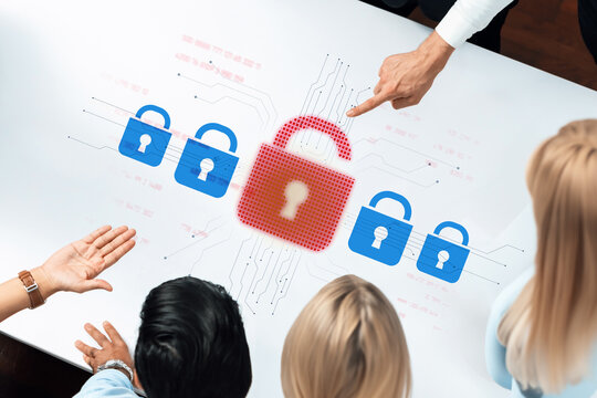 A diverse business team focuses on a digital lock symbol in a meeting room, emphasizing data security and technology solutions through collaboration and analysis. Trope