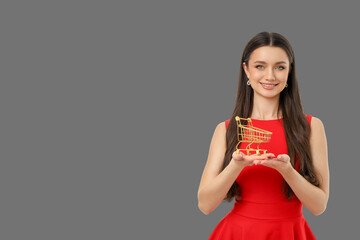 Woman holding a small shopping cart, smiling brightly