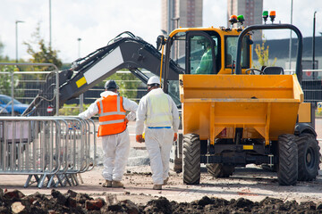 Safety and protective measures undertaken as skilled professionals in full protective suits meticulously inspecting materials containing asbestos at construction site site
