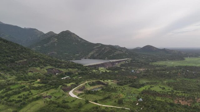 Beautiful drone shot of a dam and reservoir in the Western Ghats near Tenkasi, Tamil Nadu, with rolling hills, greenery, and peaceful natural scenery.