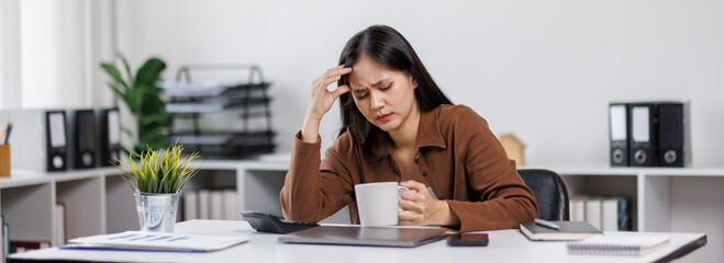 Portrait of tired young business asian woman work with documents tax laptop computer in office....