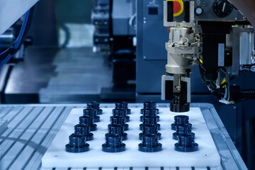 Close up industrial automation gripping robot working with metalwork on CNC lathe machine on smart manufacturing and left copy space, industry 4.0 and modern technology