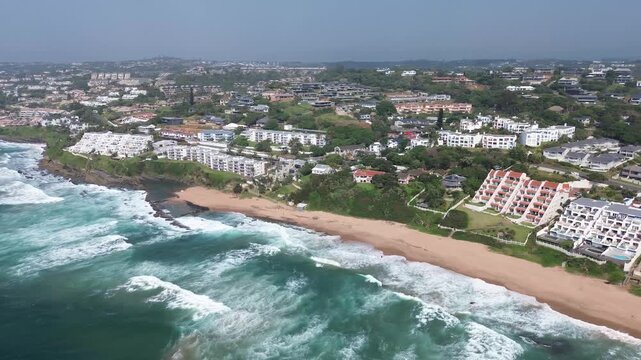 Ballito Coastal tourist town camera panning left to right over the clean, beautiful beach and town on the North Coast, KwaZulu-Natal, South Africa Aerial 4K Video