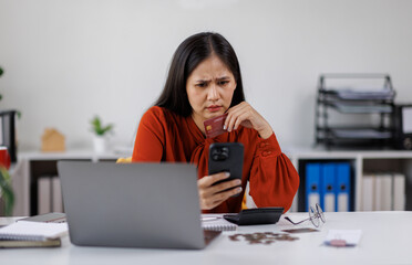 Asian woman looking at smartphone, holding credit card, finding financial problems, bad online bank service, overspending, bankruptcy risk Business financial concept, 
