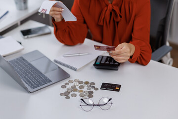 Young asian woman looking at credit card with bill invoice in her hands and worry about cash on...