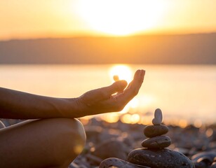 Close-up of a hand meditating near a rock stack at sunset