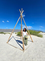 Fototapeta premium Brunette Latina adult woman walks through the gypsum dunes in the middle of the white desert enjoying the freedom and fullness of feeling nature