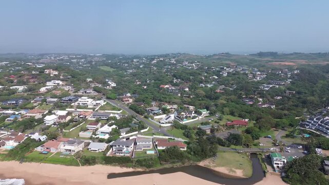Ballito Coastal tourist town camera panning right to left over the town and pristine clean beach on the North Coast, KwaZulu-Natal, South Africa Aerial 4K Video