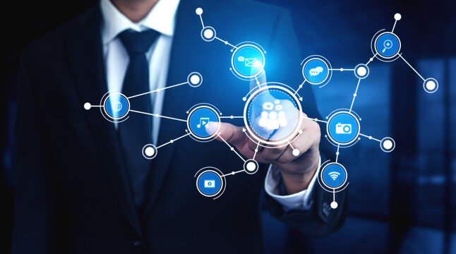 A businessman engages with a digital interface displaying various network icons, symbolizing connectivity and innovation in the modern business world. Tessel