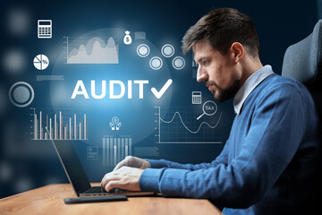 Man working on financial audit with digital graphs in a modern office setting