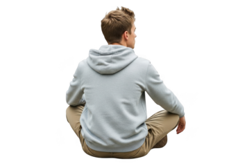 Young man with short brown hair wearing a light blue hooded sweatshirt and tan pants sitting cross legged isolated on transparent background