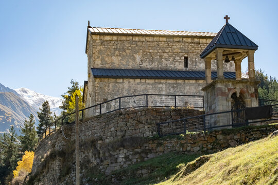 Stunning old church on a hilltop with surrounding mountains and clear sky during autumn season