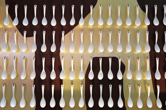Plastic spoons hanging on wall pattern background