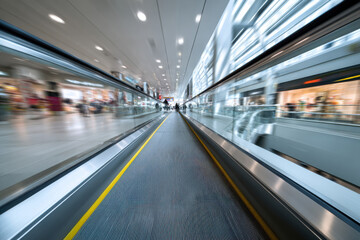 Fototapeta premium Blurred motion of escalators inside a shopping center
