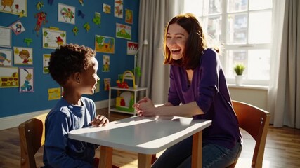 white tutor helping black boy at table, colorful classroom artwork on wall, sunlight streaming through window, playful learning with crayons and flashcards, joyful smiles and gentle encouragement - Powered by Adobe